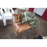 A teak two seater garden bench with cover
