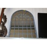 A metal framed arched mirror
