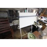 A draftsmans adjustable drawing board on stand