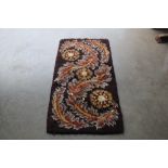 An approx. 4'6" x 2'4" floral wool rug