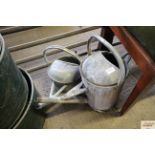 A 2.5 gallon watering can and another 1 gallon can