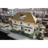 A six room dolls house with some furniture and lit