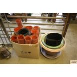 A box containing various sized plastic plant pots,