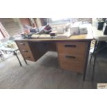 A wooden and metal legged five drawer writing desk