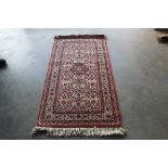 An approx. 5'8" x 2'8" floral patterned rug