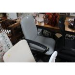 A grey upholstered swivel office chair