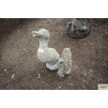 Two concrete garden ornaments in the form of a duck and a gnome