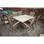 A large varnished teak garden table and six matchi