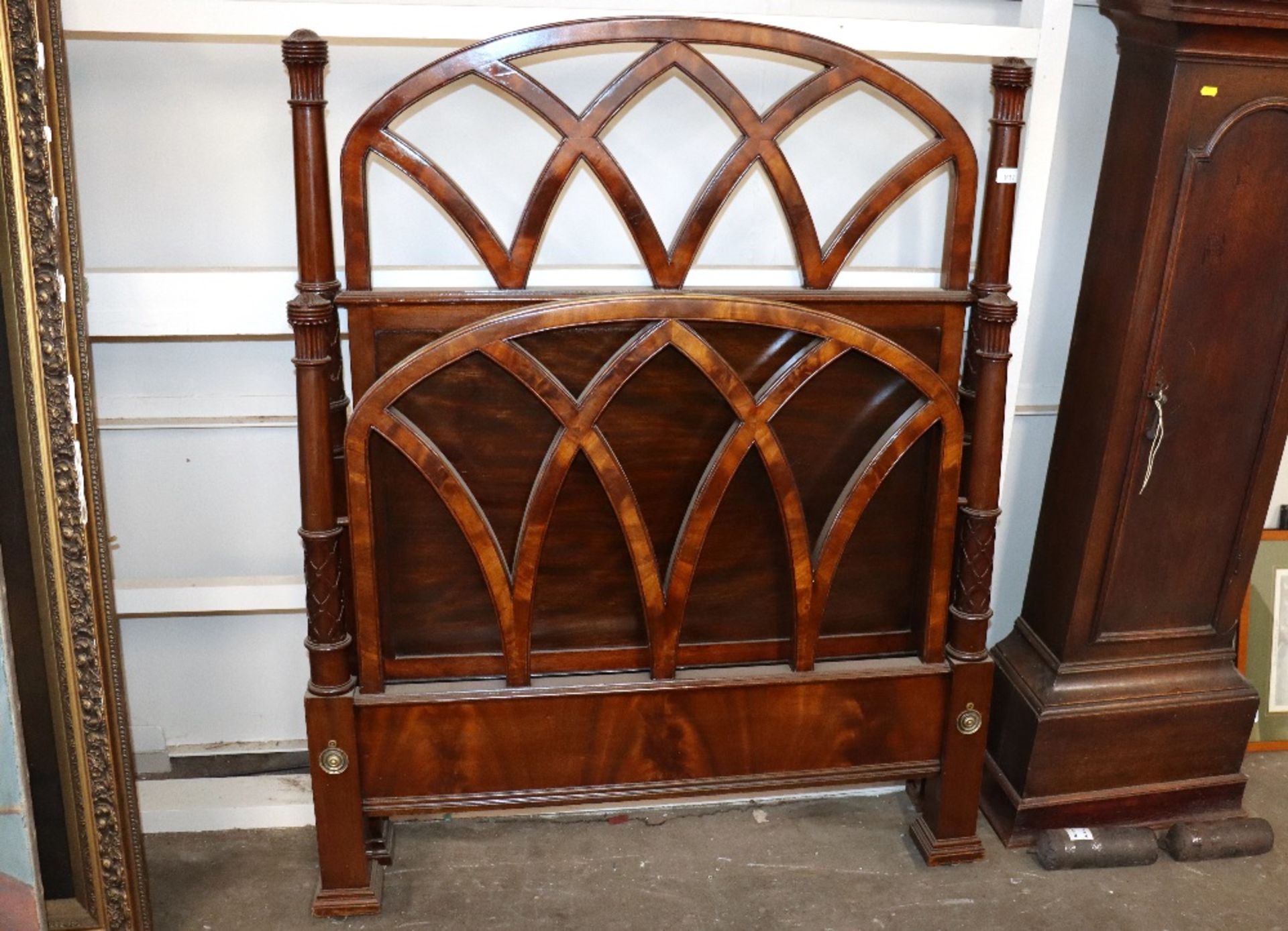 An early 20th century mahogany single bedstead with turned column and pierced latticed ends