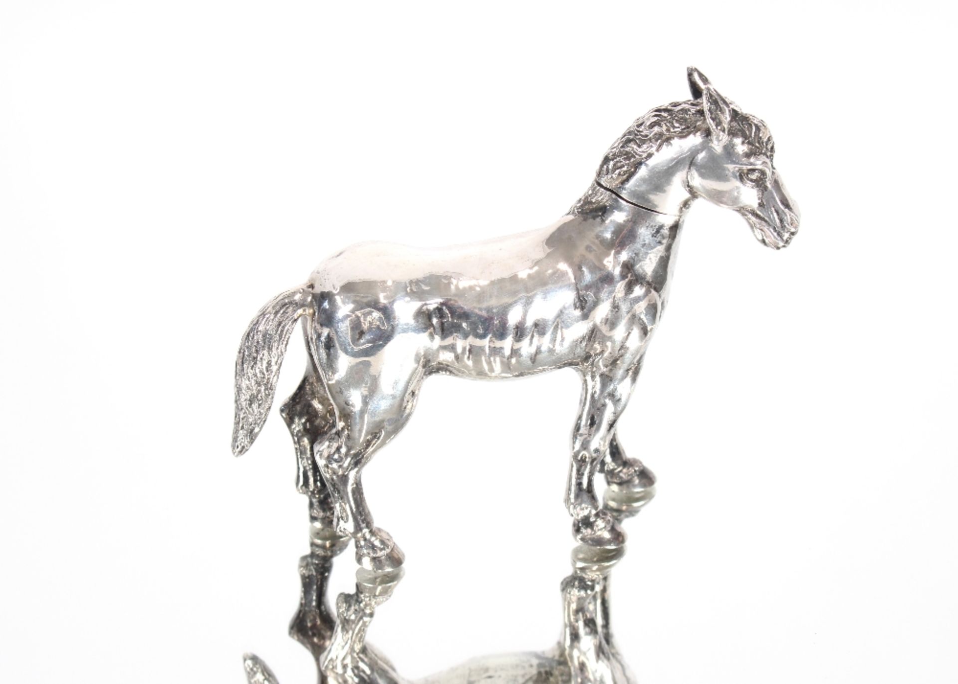 A white metal flask in the form of a pony with rem