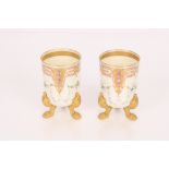 A pair of porcelain beaker vases raised on gilt cl