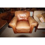 A brown leather deep seated upholstered armchair