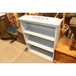 A grey painted open fronted bookcase