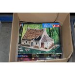 A box containing a three D puzzle and various reco