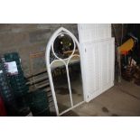 An arched metal framed outdoor mirror
