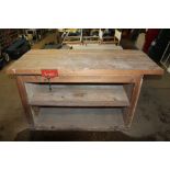 A wooden work bench with small bench vice mounted