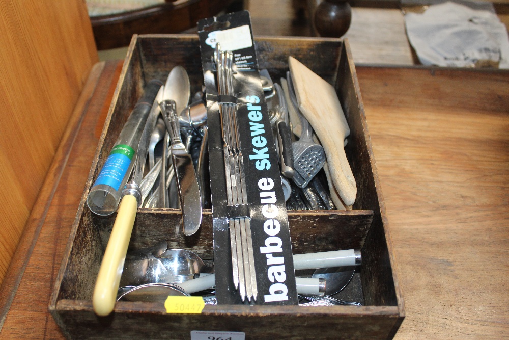 A wooden tray and contents of various cutlery and