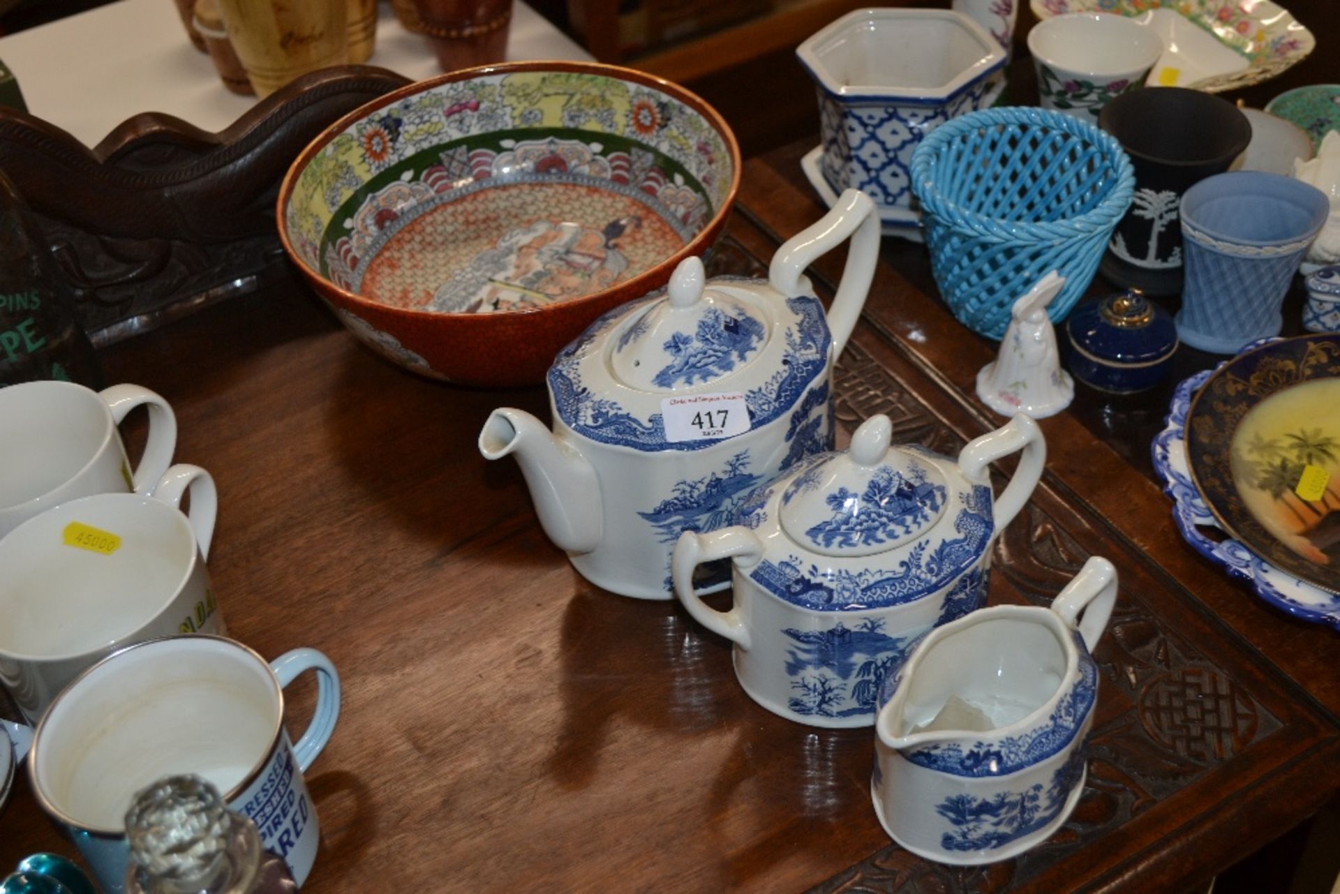 A three piece blue and white willow pattern tea se