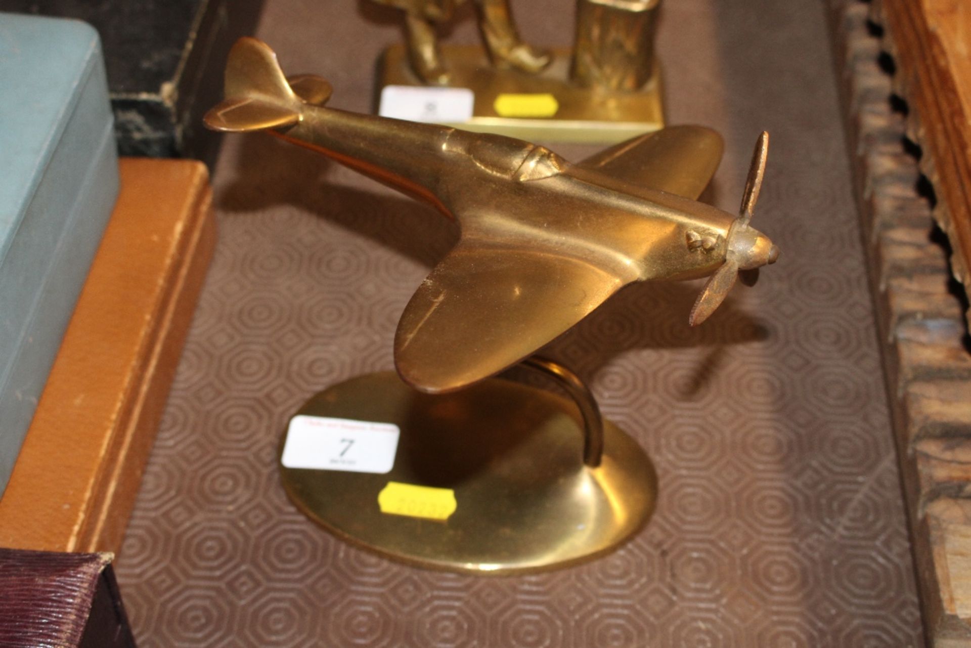A brass model of a spitfire on stand