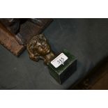 A bronzed bust of a boy raised on simulated marble