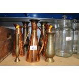 A quantity of brass vases and three copper jugs