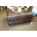 A faux leather upholstered footstool