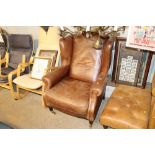 A leather upholstered wing back armchair