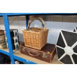 A wicker bottle carrier and a suitcase