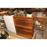 A teak bookcase enclosed by glazed sliding doors