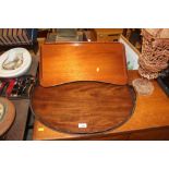 An oval mahogany two handled tea tray and a bed tr