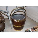 An oak and brass bound coal bucket with swing hand