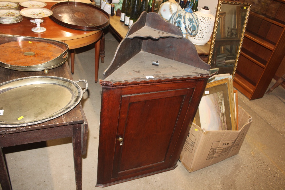 An antique oak hanging corner cupboard