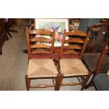 A pair of antique elm and rush seated ladder back