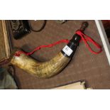 A powder horn, having scrimshaw decoration depicti