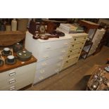 A white laminate chest of five drawers