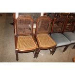 A pair of French walnut cane panelled side chairs