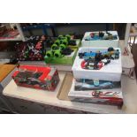 Two Formula 1 remote control cars; one other remot