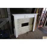 A wooden fire surround and cut marble fireplace in