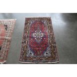 An approx. 4'3" x 2'6" red and blue pattern rug