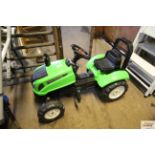 A plastic child's pedal garden tractor