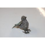 A white metal bird ornament set with turquoise sto