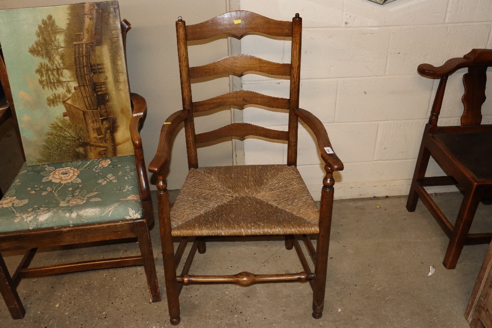 An antique elm ladder back elbow chair with rush s