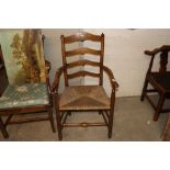 An antique elm ladder back elbow chair with rush s