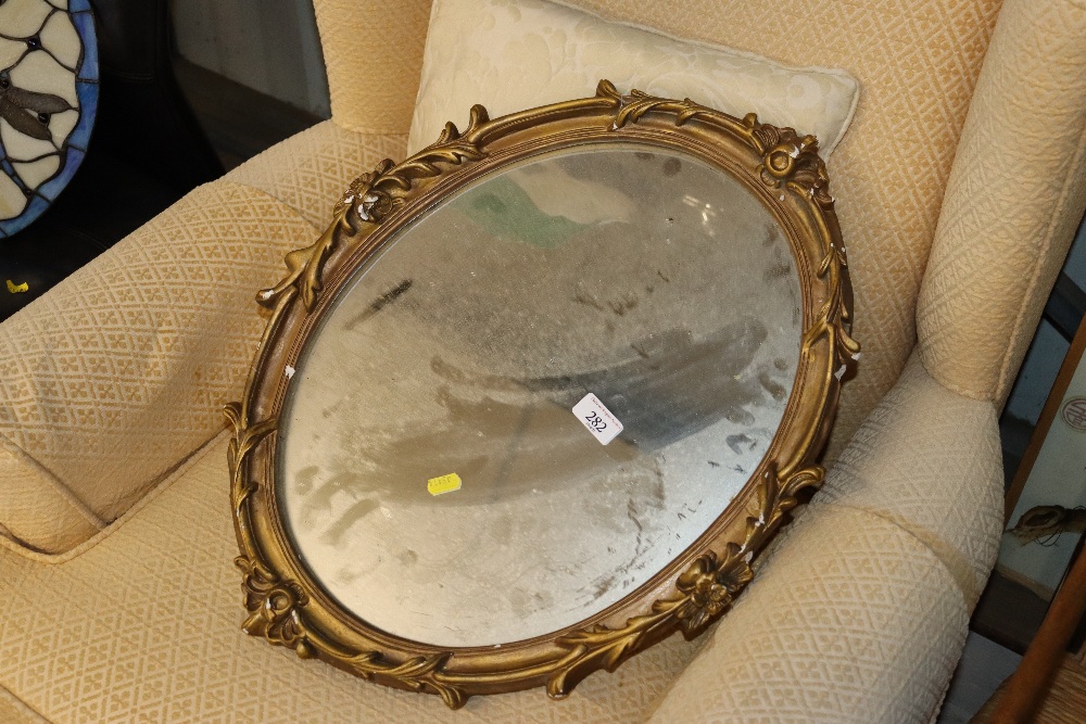 An oval ornate gilt framed wall mirror