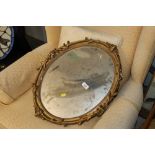 An oval ornate gilt framed wall mirror