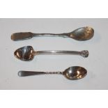 A silver spoon and two white metal spoons