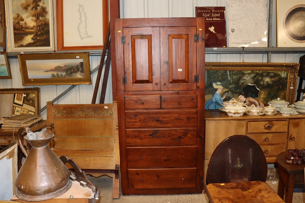 A dark pine storage cupboard fitted five drawers b