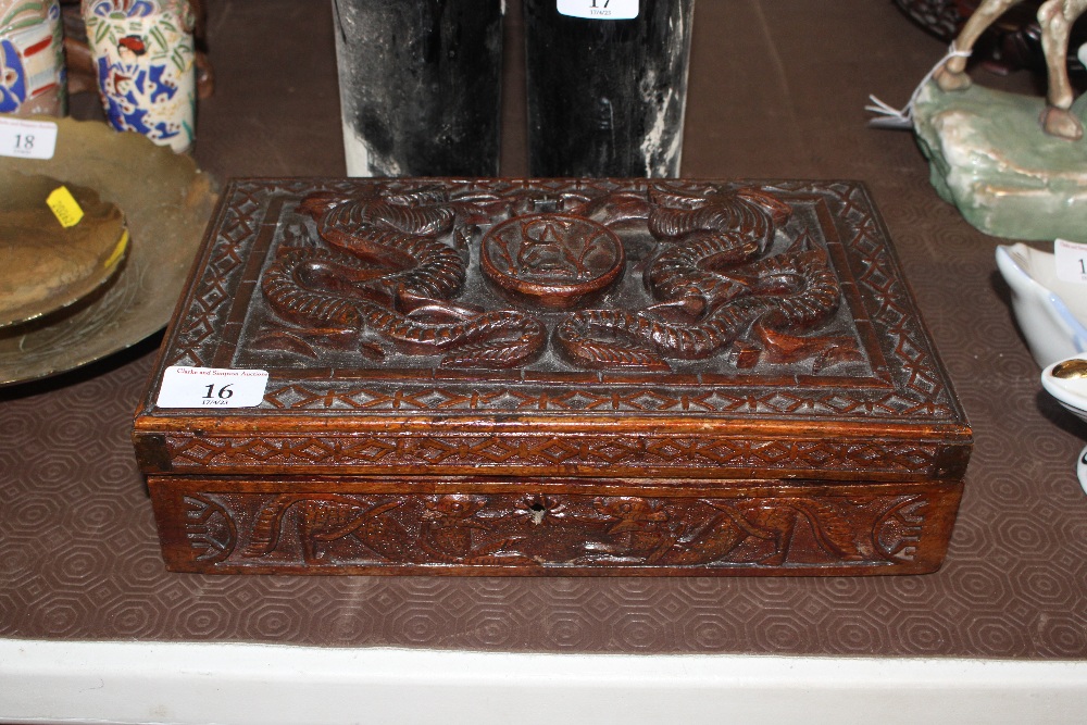 An Oriental carved wooden box decorated with drago