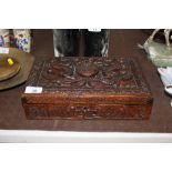 An Oriental carved wooden box decorated with drago