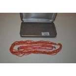 A multi strand coral necklace with gilt clasp; and